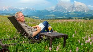 Rick Steves relaxing in a Dolomites field